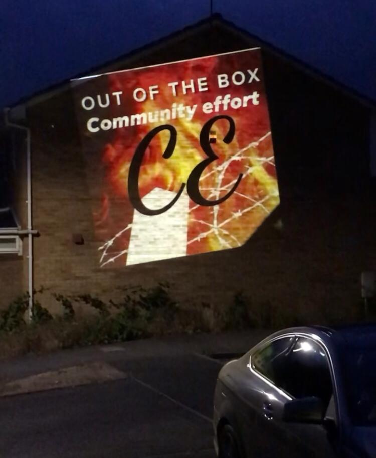Out of the Box Community Effort logo projected against a wall